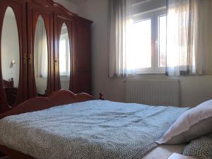 ein Schlafzimmer mit einem großen Bett und einem Fenster in der Unterkunft Apartman Cypres in Kupres