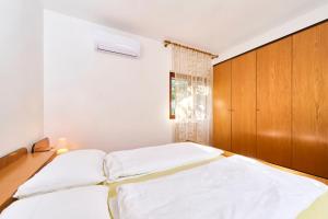 sypialnia z łóżkiem i drewnianym zagłówkiem w obiekcie Anna Apartments w mieście Zambratija