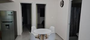 a white table and chairs in a room with a refrigerator at Departamento Aeropuerto Puebla in Huejotzingo