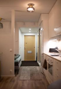 Habitación con pasillo con puerta y cocina en New studio apartment with free parking, en Kuopio