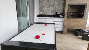 a ping pong table in a kitchen with two red balls at Casa 4 quartos com Piscina e Jacuzzi em Jurerê in Florianópolis