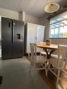 a kitchen with a wooden table and a refrigerator at Mini Casa na praia! in Bombinhas