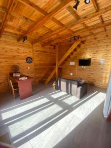 Habitación con techo de madera, mesa y escritorio. en Cabana dos Pinheiros Chalé com Jacuzzi, en Florianópolis