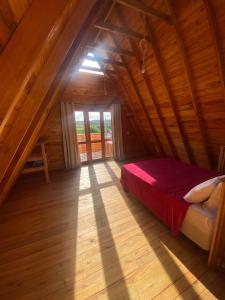 1 dormitorio con 1 cama en un ático de madera en Cabana dos Pinheiros Chalé com Jacuzzi, en Florianópolis