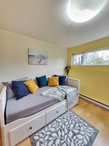 a bedroom with a bed with blue and yellow pillows at Sunshine Suite in Vancouver