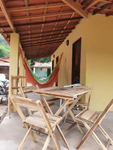 einen Holztisch und Stühle auf einer Terrasse in der Unterkunft Chalés Caiçara Praia de Ponta Grossa in Icapuí