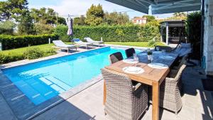 a dining table and chairs next to a swimming pool at Villa Marietta The First in Hanioti