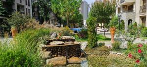 a garden with a fountain in the middle of a street at Cascadas Family Resort 2-Rooms Apartment sunny beach in Sunny Beach