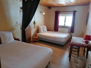 a hotel room with two beds and a window at Hôtel Le Lievre Blanc in Vars