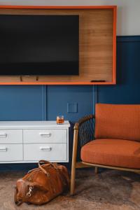 a chair and a television on a wall with a purse at Bardstown Motor Lodge in Bardstown