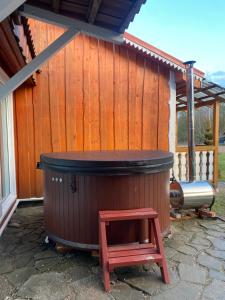 a hot tub with a stool in front of a building at Homestead - Ukmergė area 