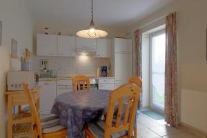 a kitchen with a table and chairs and a kitchen with a window at DW10a FeWo Diekkieker in Spieka-Neufeld