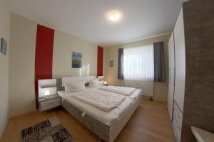 ein Schlafzimmer mit einem Bett und einer rot-weißen Wand in der Unterkunft DW10a FeWo Diekkieker in Spieka-Neufeld