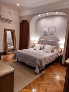 1 dormitorio con 1 cama grande y espejo grande en Departamentos en el Centro de Buenos Aires en Buenos Aires