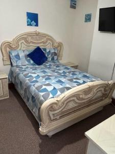 a bedroom with a bed with a blue and white comforter at Busy Bee - Guest House - Self Service in Leigh