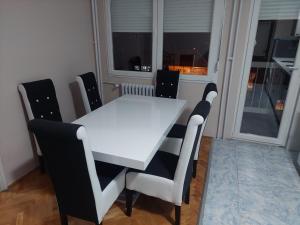 a white table and chairs in a room with a window at Rajna in Pirot +4 photos