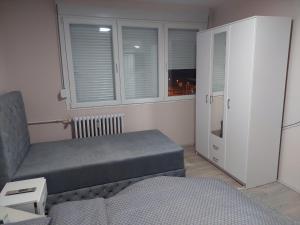 een slaapkamer met een bed, een kast en een raam bij Rajna in Pirot