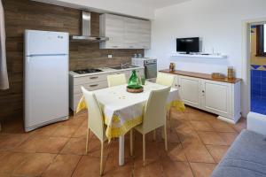 cocina con mesa con sillas y nevera blanca en Tenuta Ferilli, en Salve