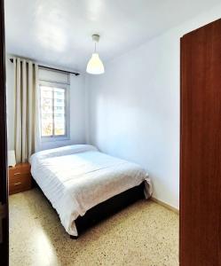 Schlafzimmer mit einem Bett und einem Fenster in der Unterkunft Apartamento Diagonal Mar, cerca del Forum y la playa in Barcelona