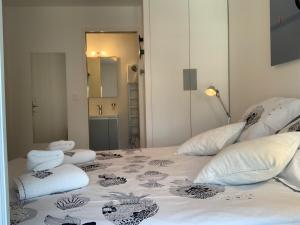 a bedroom with a bed with white sheets and pillows at LE TI ROCHELAIS, superbe appart, design, cosy, vieux-port au calme in La Rochelle