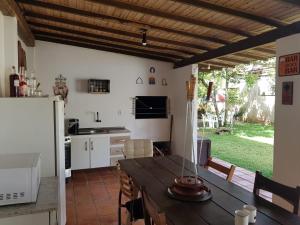 cocina y comedor con mesa de madera en Suíte c/ acesso independente, 4 quadras do mar!, en Torres