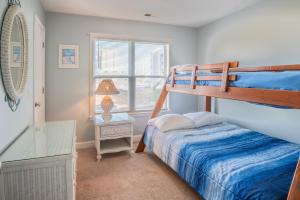 a bedroom with two bunk beds and a desk at Oceanview Condo Near the Boardwalk - Sea Drift Carolina Breezin in Carolina Beach