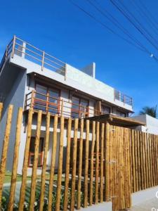 a house with a wooden fence in front of it at CASA Rio Mar Paripueira in Paripueira