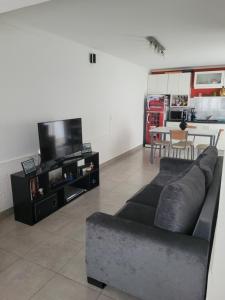 a living room with a couch and a tv at Departamento Completo y muy buena ubicación in Tandil