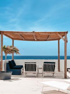 two chairs and a gazebo on the beach at BijBlauw in Willemstad