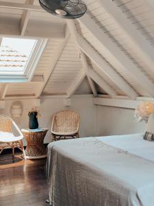 a bedroom with a bed and two chairs and a window at BijBlauw in Willemstad