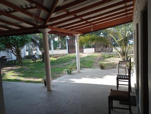 a patio with two chairs under a wooden pergola at Surf Forever in Midigama