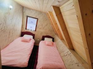 two beds in a small room with a window at Konak Mara- Komovi in Andrijevica