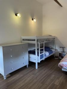 a bedroom with two bunk beds and a dresser at Gîte le Ch'armançon in Montigny-sur-Armançon