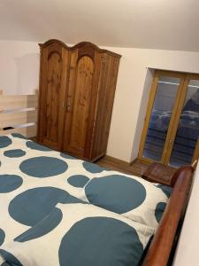 a bedroom with a bed with a blue and white blanket at Gîte le Ch'armançon in Montigny-sur-Armançon