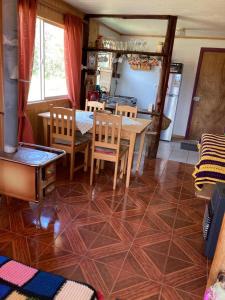 cocina y comedor con mesa y sillas en Cabañas encanto del bosque, en Castro