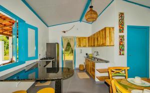 a kitchen with blue and white walls and a table at Casinha Branca MSP - Casa na Quarta Praia in Morro de São Paulo
