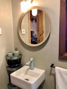 ein Badezimmer mit einem weißen Waschbecken und einem Spiegel in der Unterkunft Quintinha da Oliveira in Marco de Canavezes