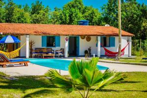 a villa with a swimming pool and a house at Casinha Branca MSP - Casa na Quarta Praia in Morro de São Paulo