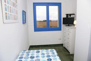 ein Schlafzimmer mit einem blauen Fenster und einem Bett in der Unterkunft Pensió Solivent in L'Escala