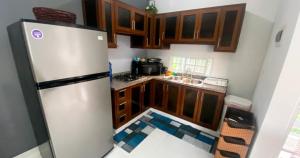 a kitchen with a refrigerator and wooden cabinets at Quiet Apartment, 3 Minutes From The Beach, 24H Security, Excellent Internet in San Felipe de Puerto Plata +38 photos