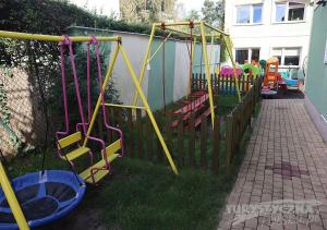 un patio con un parque infantil con sillas y columpios en Ośrodek Wypoczynkowy Romed, en Jastrzębia Góra
