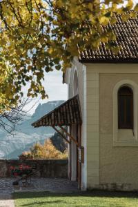 a building with a bench and a view of the mountains at Gasthof Kohlern 1130 m in Bolzano