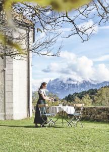 a woman sitting at a table with a glass of wine at Gasthof Kohlern 1130 m in Bolzano