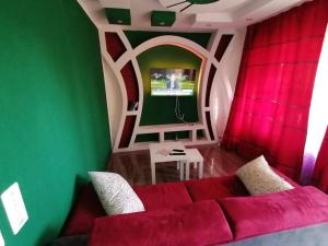 sala de estar con sofá rojo y pared verde en Luxury Voll möblierte 2 Zimmer Appartement Aarau en Küttigen