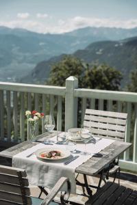 a table with a plate of food and wine glasses at Gasthof Kohlern 1130 m in Bolzano