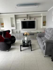 a living room with two couches and a tv at Apartamento en Cañaveral in Floridablanca