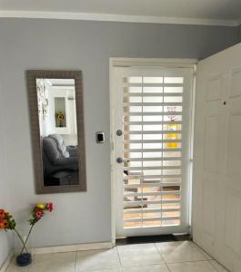 a white room with a door with a mirror and a mirror at Apartamento en Cañaveral in Floridablanca