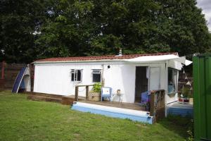 a small white cottage with a large porch at Rockets's Retreat in Bursledon