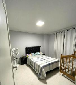 a bedroom with a bed and a fan at Apartamento en Cañaveral in Floridablanca