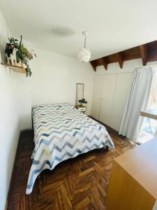 1 dormitorio con 1 cama con manta azul y blanca en Departamento con balcón estilo escandinavo Zona centro en Córdoba